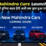 5 नई Mahindra कारें – XEV 7e, BE Rall-E, XUV 7OO, XUV 3XO EV और New Bolero – एक लॉन्च इवेंट में स्टेज पर प्रदर्शित हैं, स्क्रीन पर 'Coming Soon' लिखा है